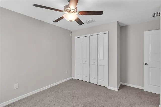 an empty room with chandelier fan