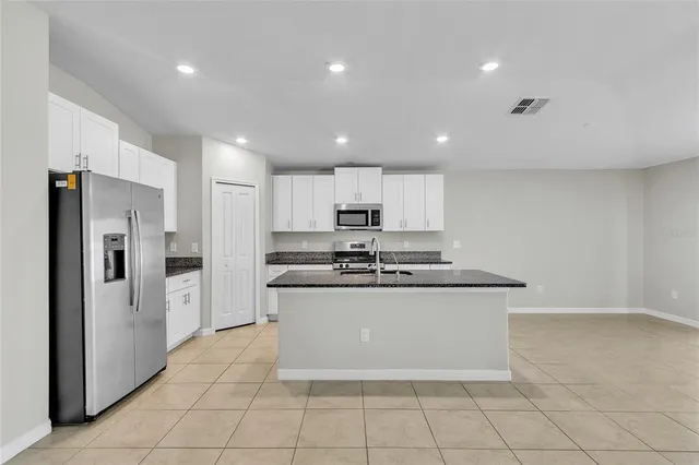 a kitchen with stainless steel appliances granite countertop a refrigerator sink and stove