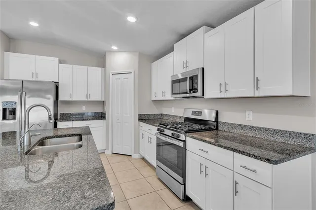a kitchen with a sink granite counter top a sink and dishwasher