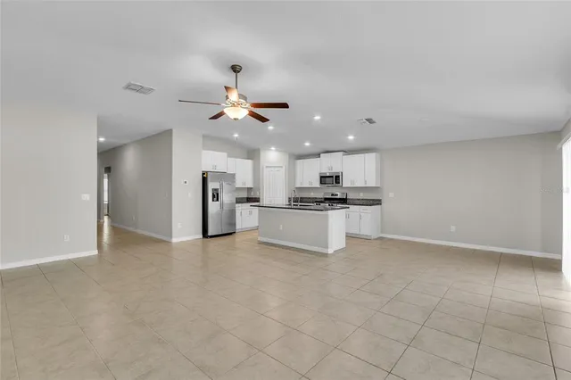 a kitchen with stainless steel appliances a refrigerator sink and white cabinets