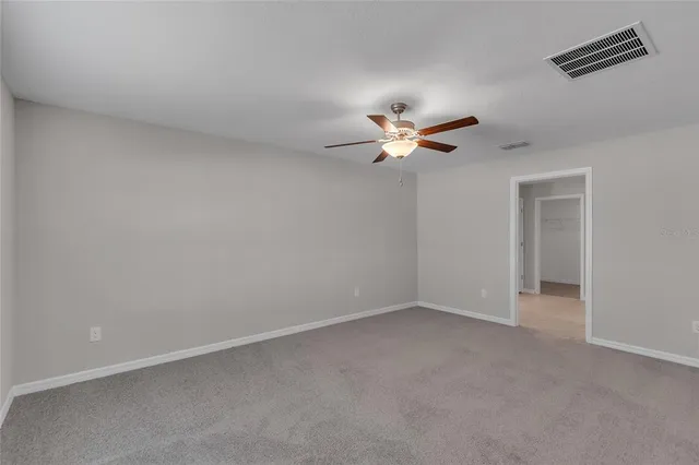 an empty room with a window and a fan