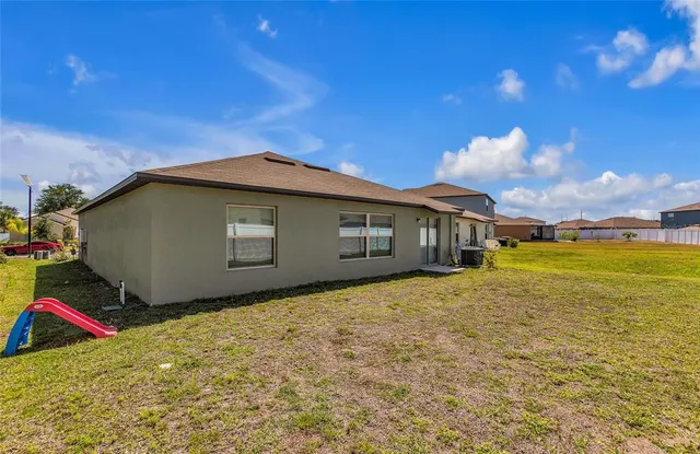 a view of an house with backyard space and balcony