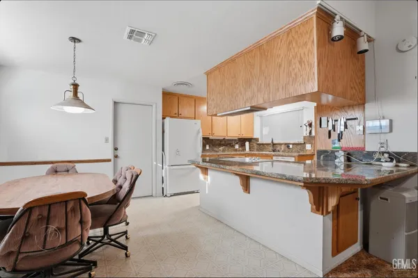 a kitchen with stainless steel appliances granite countertop a sink and a refrigerator