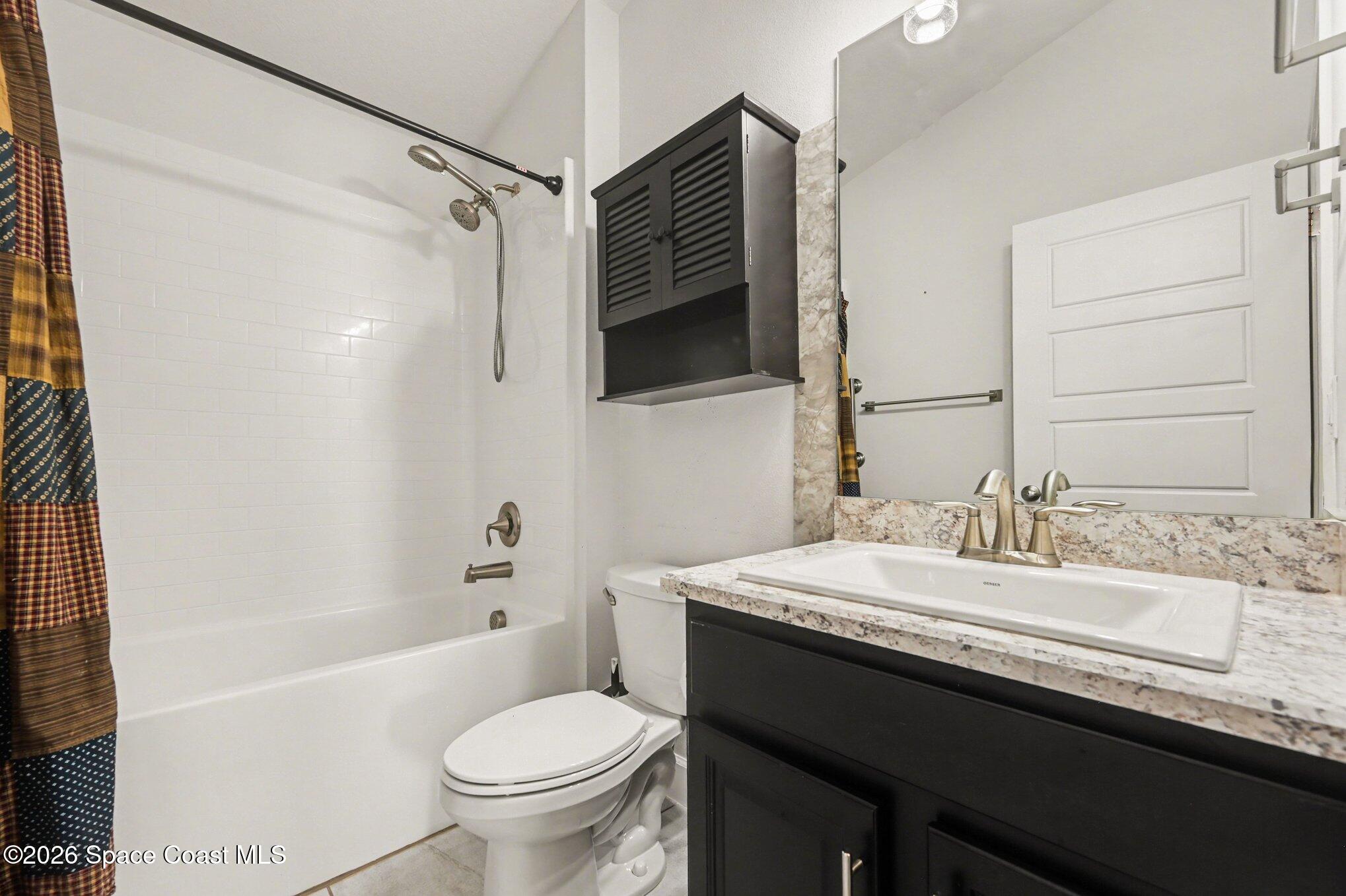 831 Tupelo Circle Cocoa, FL 32926 - Photo 13 of 23 a bathroom with a granite countertop sink toilet and shower