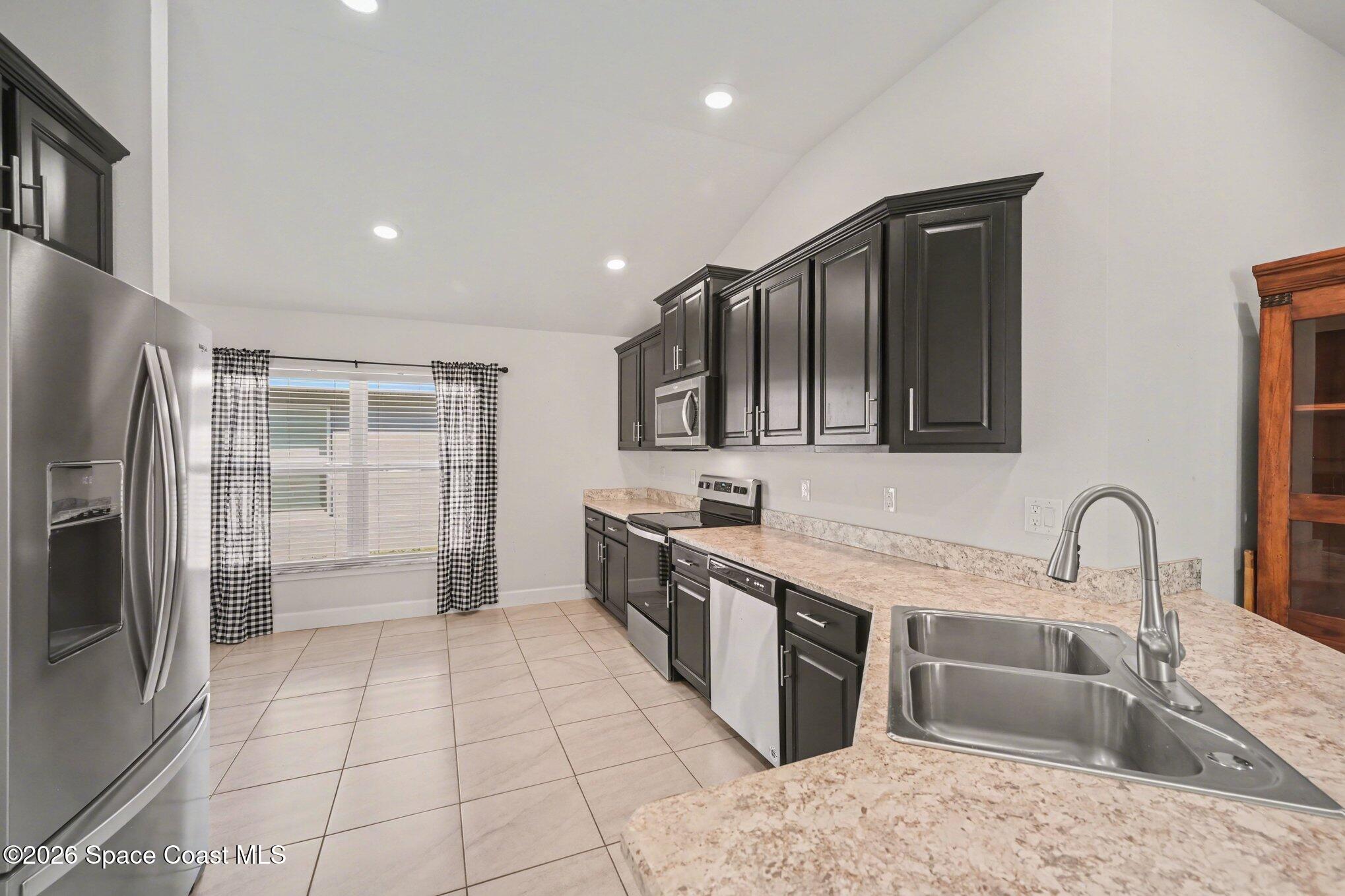 831 Tupelo Circle Cocoa, FL 32926 - Photo 4 of 23 a kitchen with stainless steel appliances granite countertop a sink and a refrigerator