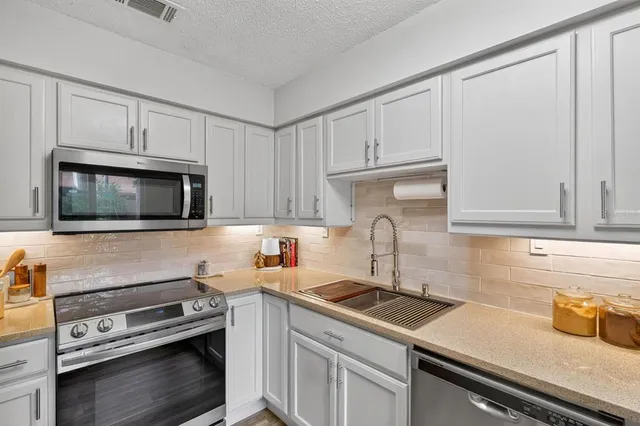 a kitchen with a sink stove and microwave