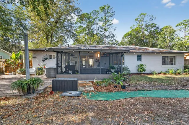 a view of house with backyard and outdoor seating