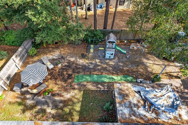 an aerial view of residential houses with outdoor space and trees