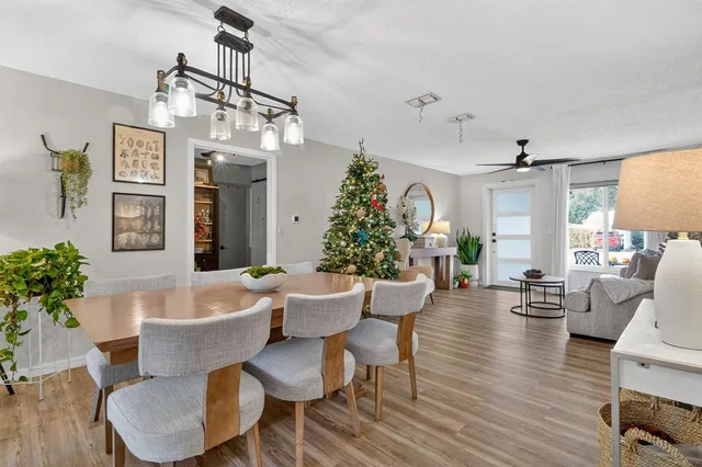 a living room with furniture a chandelier and wooden floor