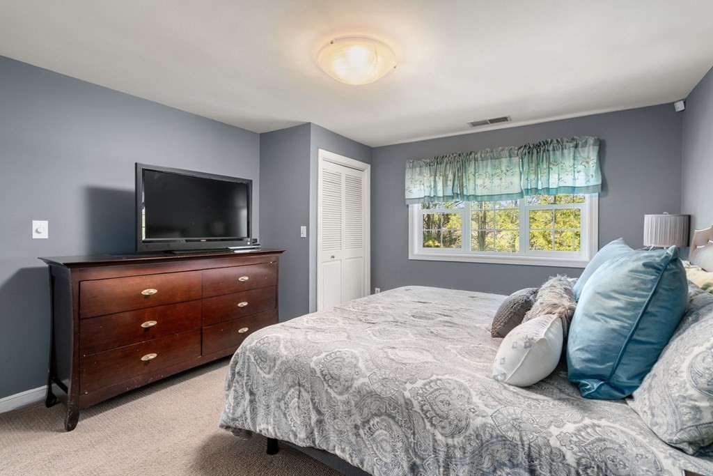 55 Glover Road Needham, MA 02494 - Photo 14 of 22 a bedroom with a bed and a flat screen tv