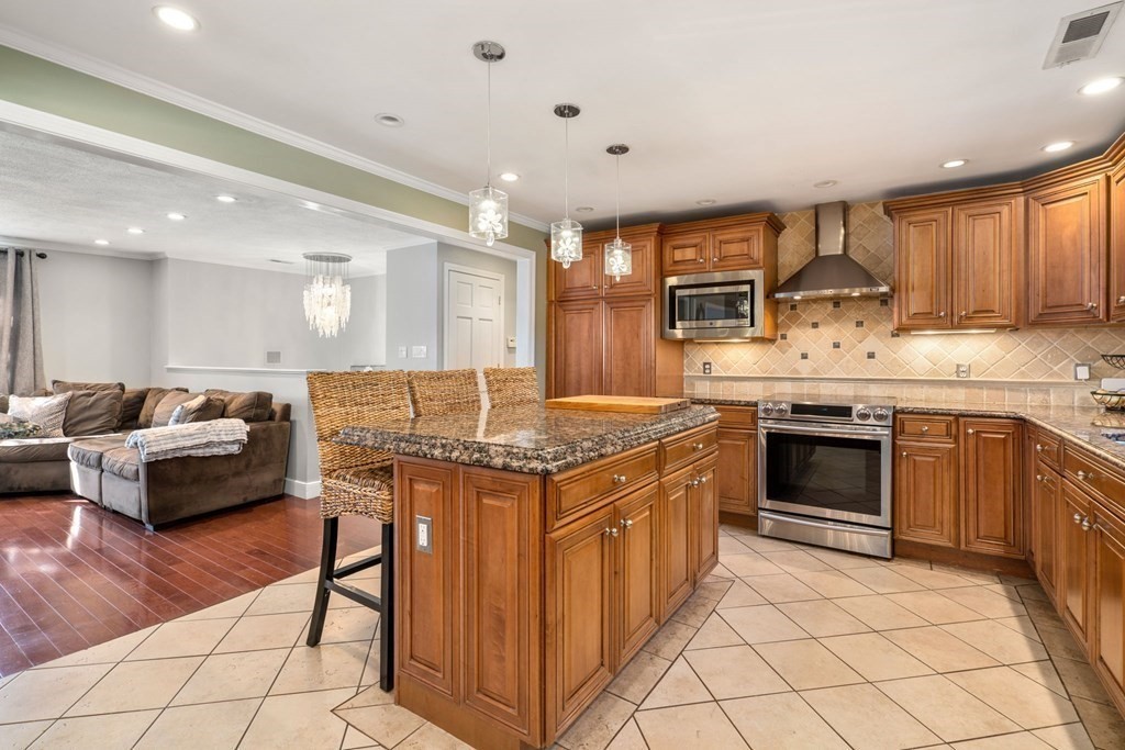 55 Glover Road Needham, MA 02494 - Photo 6 of 22 a kitchen with stainless steel appliances granite countertop a stove and a refrigerator