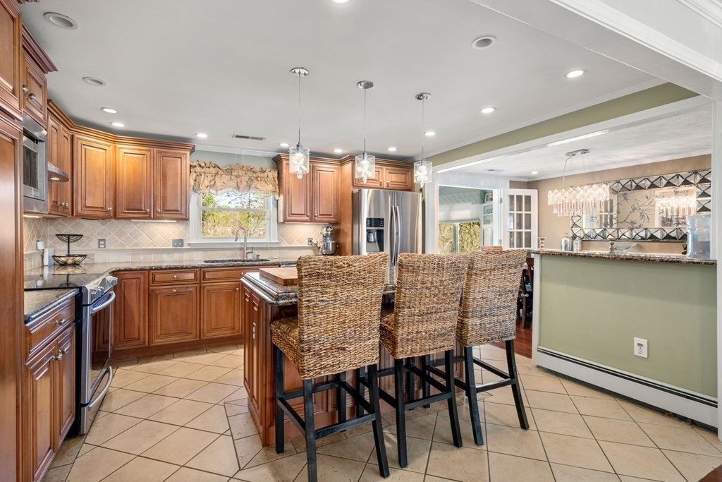 55 Glover Road Needham, MA 02494 - Photo 7 of 22 a kitchen with a table chairs sink and cabinets