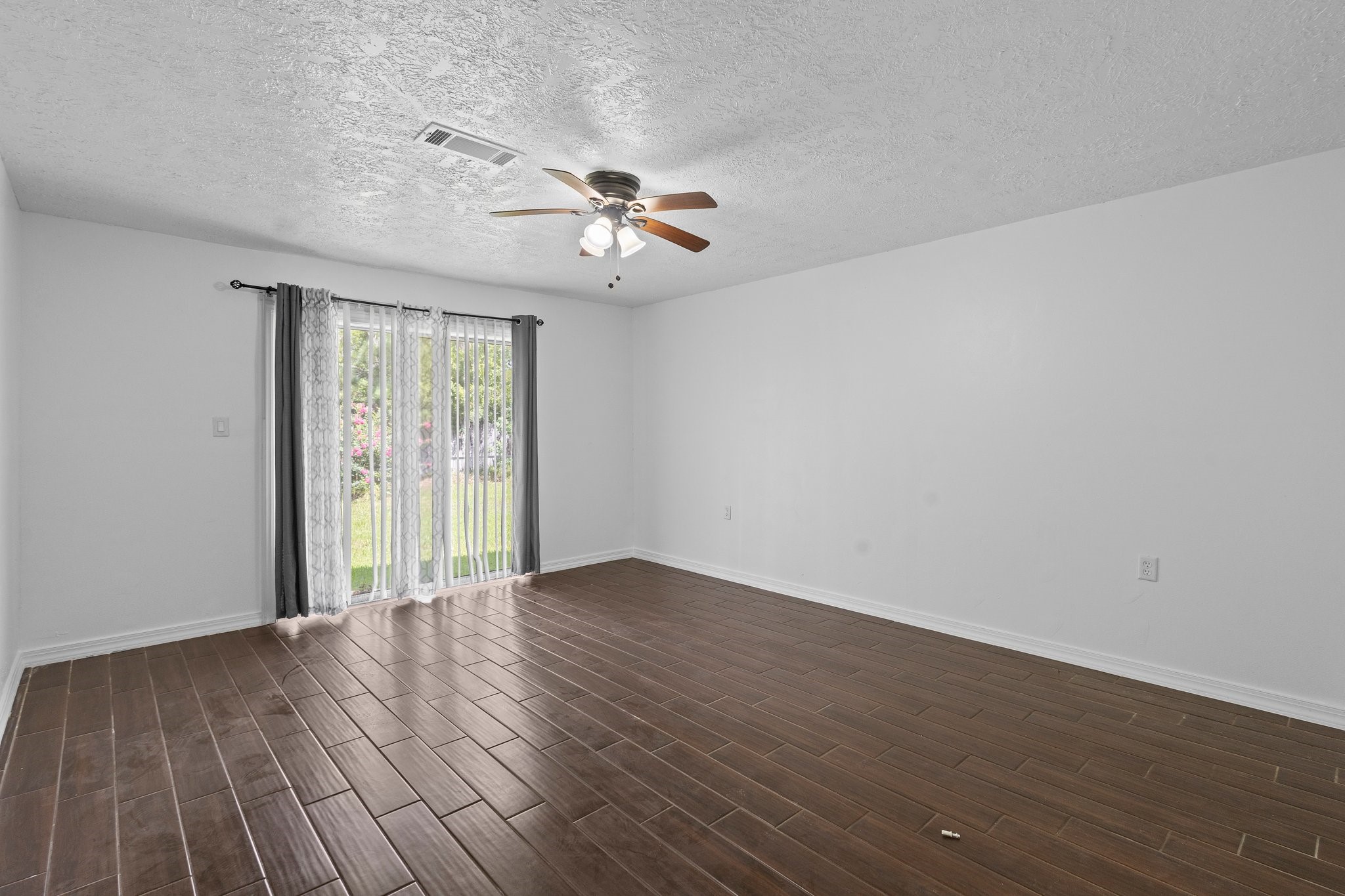6281 25th Street Groves, TX 77619 - Photo 20 of 26 an empty room with wooden floor fan and windows