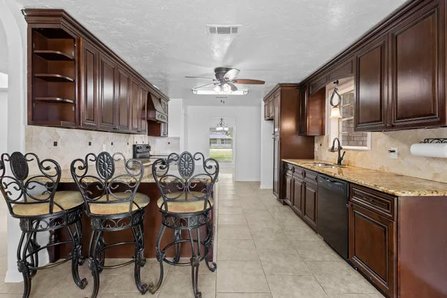 a kitchen with stainless steel appliances a sink stove and cabinets
