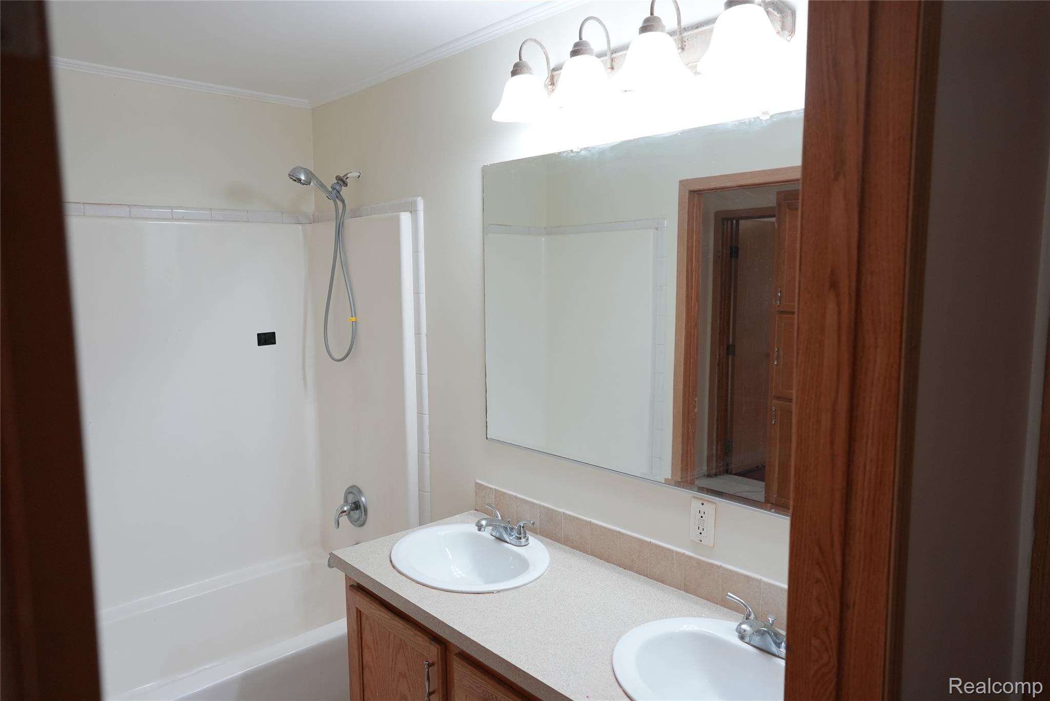2018 John R Road Troy, MI 48083 - Photo 40 of 57 Double vanity with integrated sinks, wood-finish cabinetry, and a full-width mirror