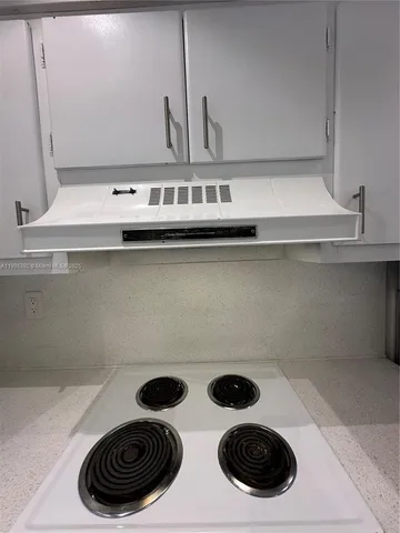 a kitchen with a stove and a wooden floor