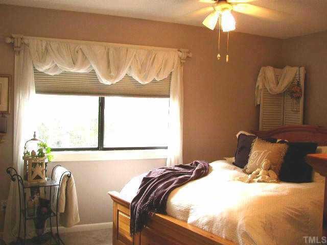 6925 Staghorn Lane Raleigh, NC 27615 - Photo 5 of 12 a bedroom with a bed and chandelier