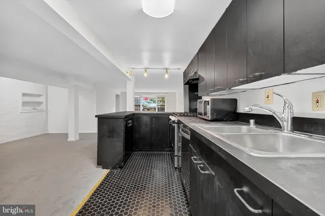 a kitchen with stainless steel appliances granite countertop a sink a stove and a refrigerator