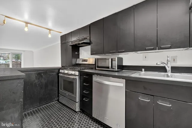 a kitchen with a sink cabinets and stainless steel appliances