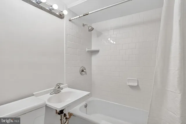 a bathroom with a bathtub a sink a toilet and a mirror