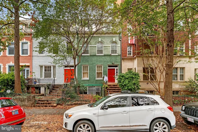 a car parked in front of a white house