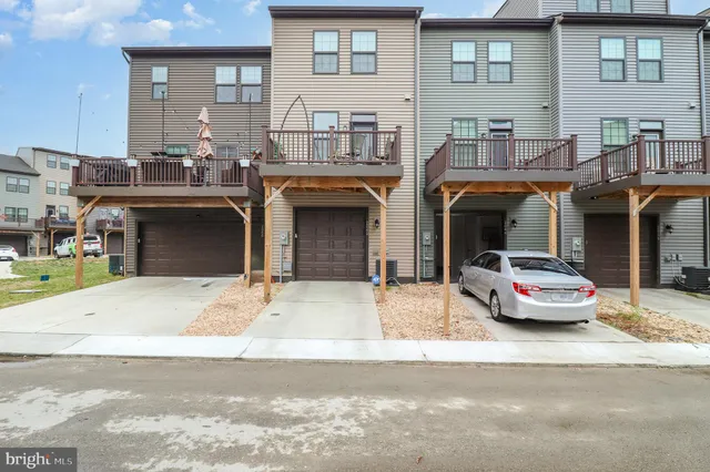 a front view of a house with barbeque and parking