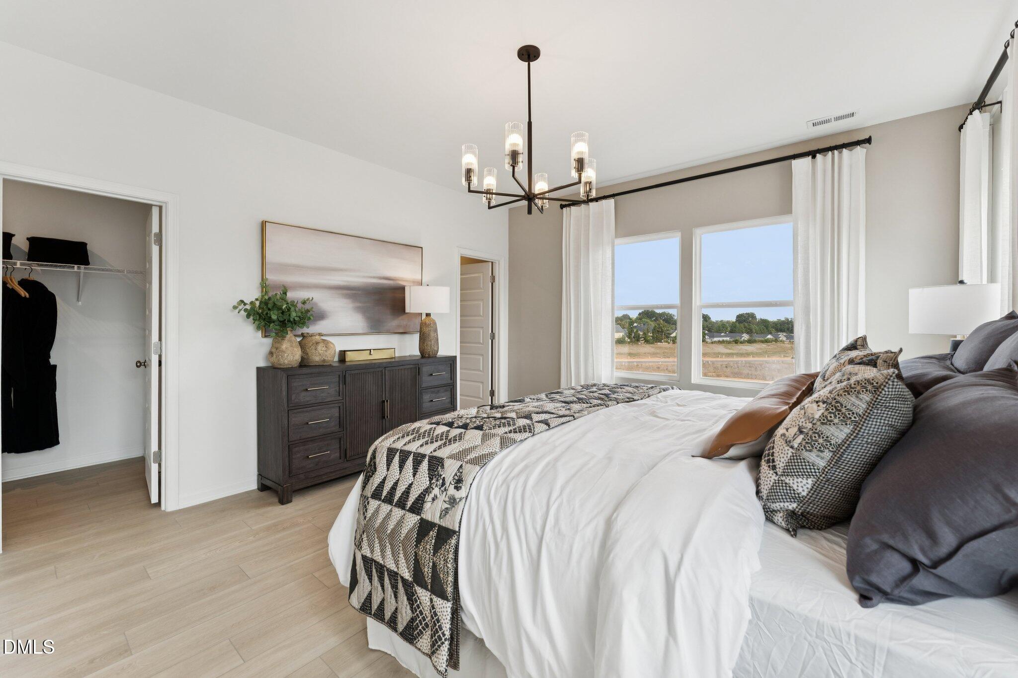 3108 Bomore Road Raleigh, NC 27610 - Photo 21 of 32 a bedroom with a bed and a chandelier