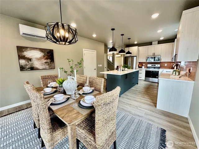 a kitchen with stainless steel appliances kitchen island granite countertop a table and chairs in it