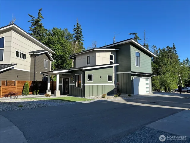 a view of a back yard of the house with a bench