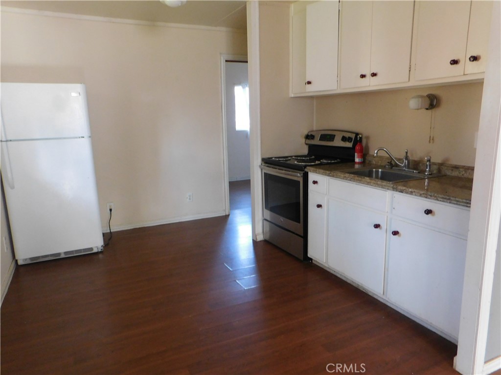15868 Main Street Middletown, CA 95461 - Photo 11 of 16 a kitchen with granite countertop white cabinets and white appliances