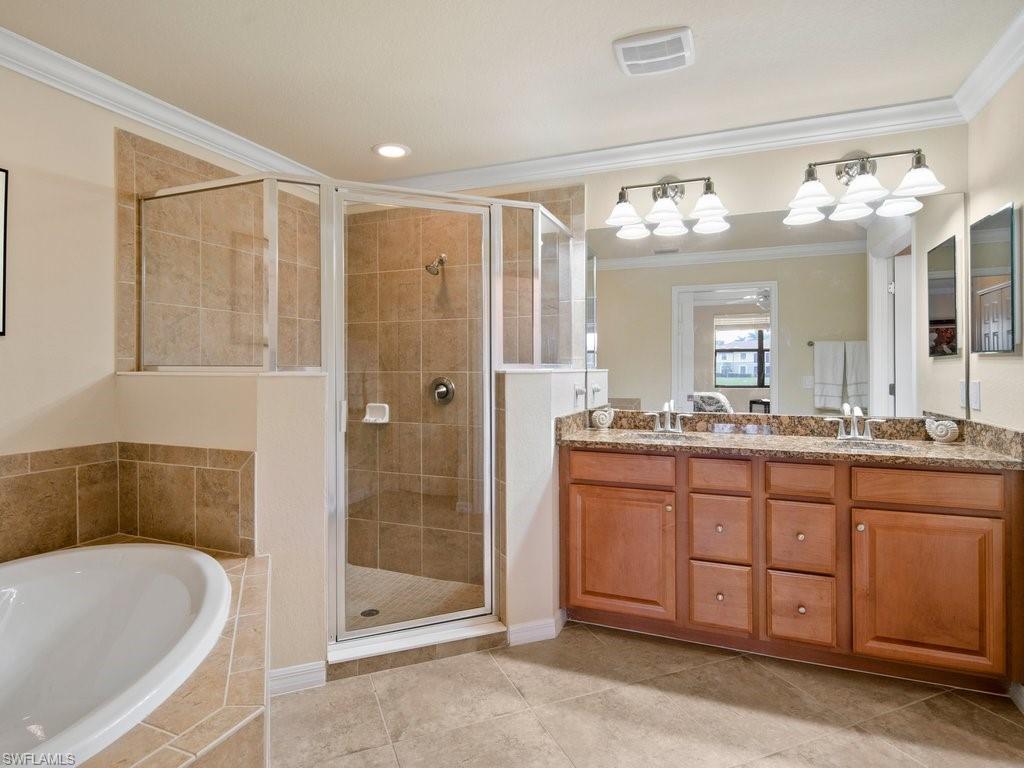 9118 Prima Way, Unit 101 Naples, FL 34113 - Photo 14 of 22 a spacious bathroom with a granite countertop sink mirror and a bathtub