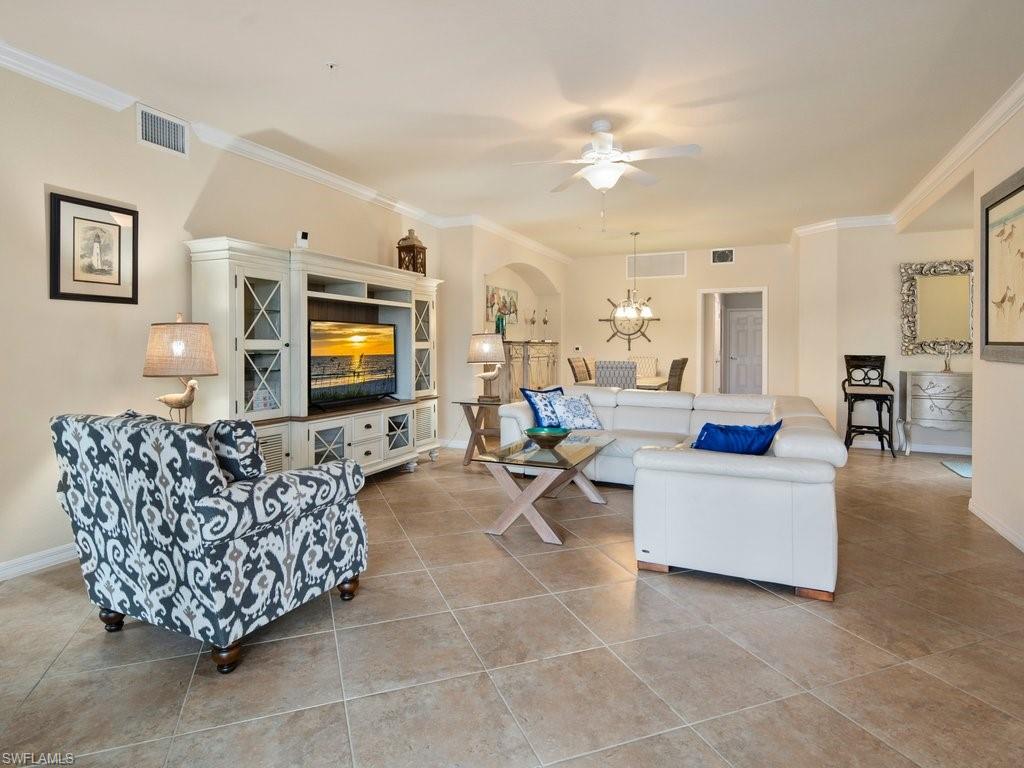 9118 Prima Way, Unit 101 Naples, FL 34113 - Photo 4 of 22 a living room with furniture and a flat screen tv
