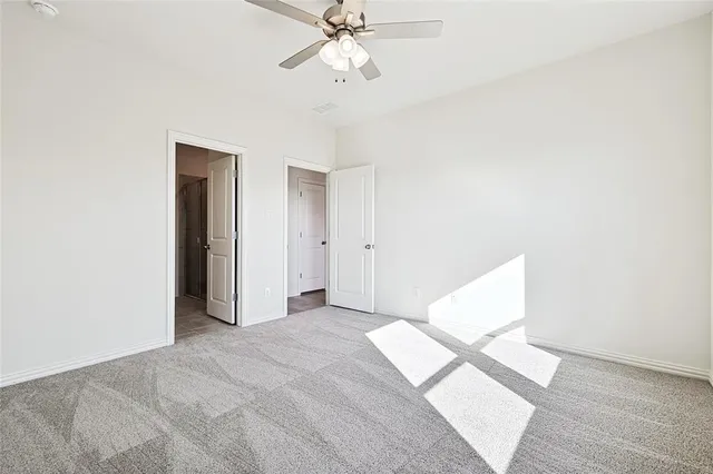 a view of a bedroom with wooden floor and chandelier fan