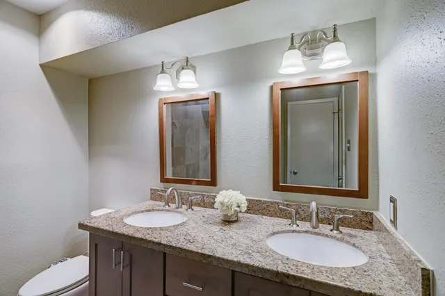 a bathroom with double vanity sinks and a mirror