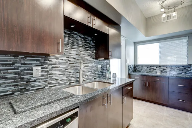 a kitchen with granite countertop a sink and a stove
