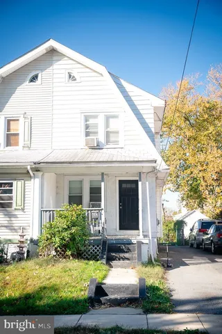 a view of a white house next to a yard