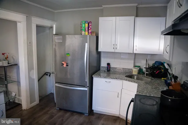 a kitchen with a refrigerator a stove a sink and cabinets