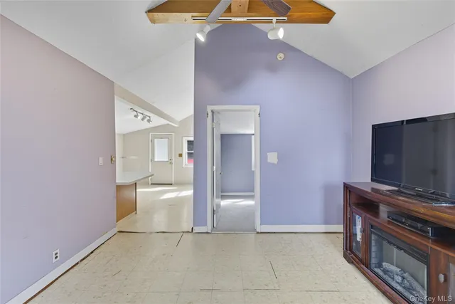a view of an empty room with a fireplace and a chandelier