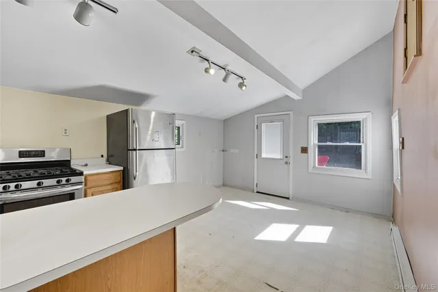 a kitchen with a refrigerator and white cabinets