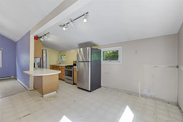 a view of a kitchen with refrigerator and windows