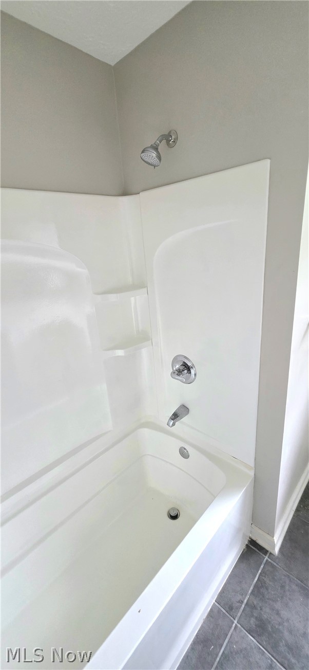252 Saxe Road Mogadore, OH 44260 - Photo 14 of 24 White bathtub with integrated shower, chrome fixtures, and built-in shelving