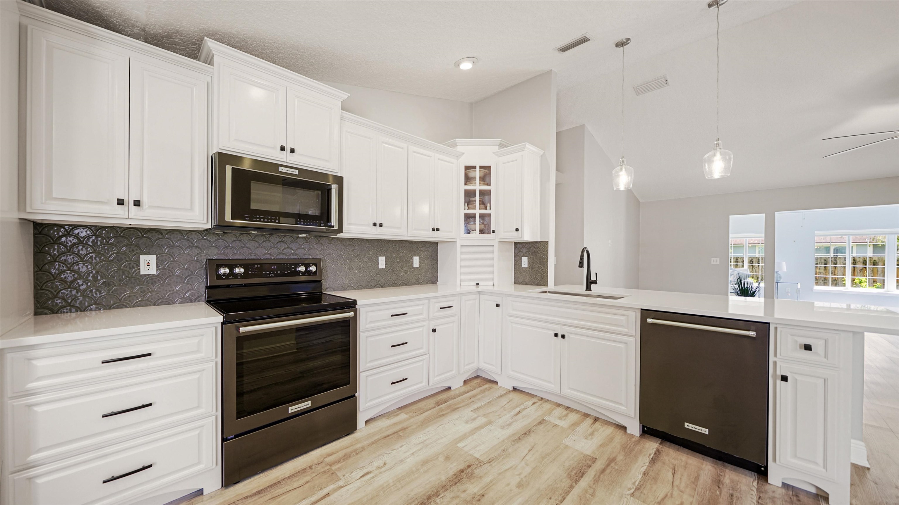 5324 5th Street St. Augustine, FL 32080 - Photo 13 of 49 a kitchen with stainless steel appliances a stove sink microwave and cabinets
