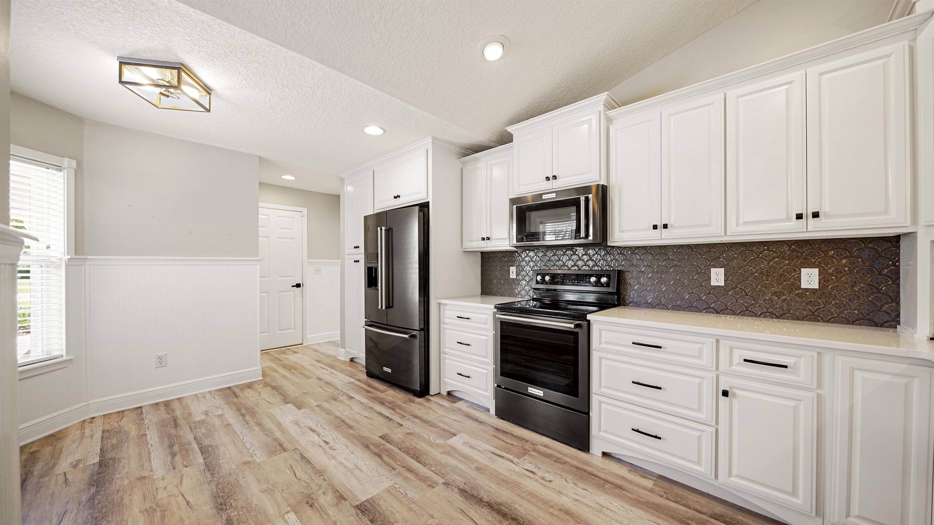 5324 5th Street St. Augustine, FL 32080 - Photo 15 of 49 a kitchen with granite countertop white cabinets and stainless steel appliances
