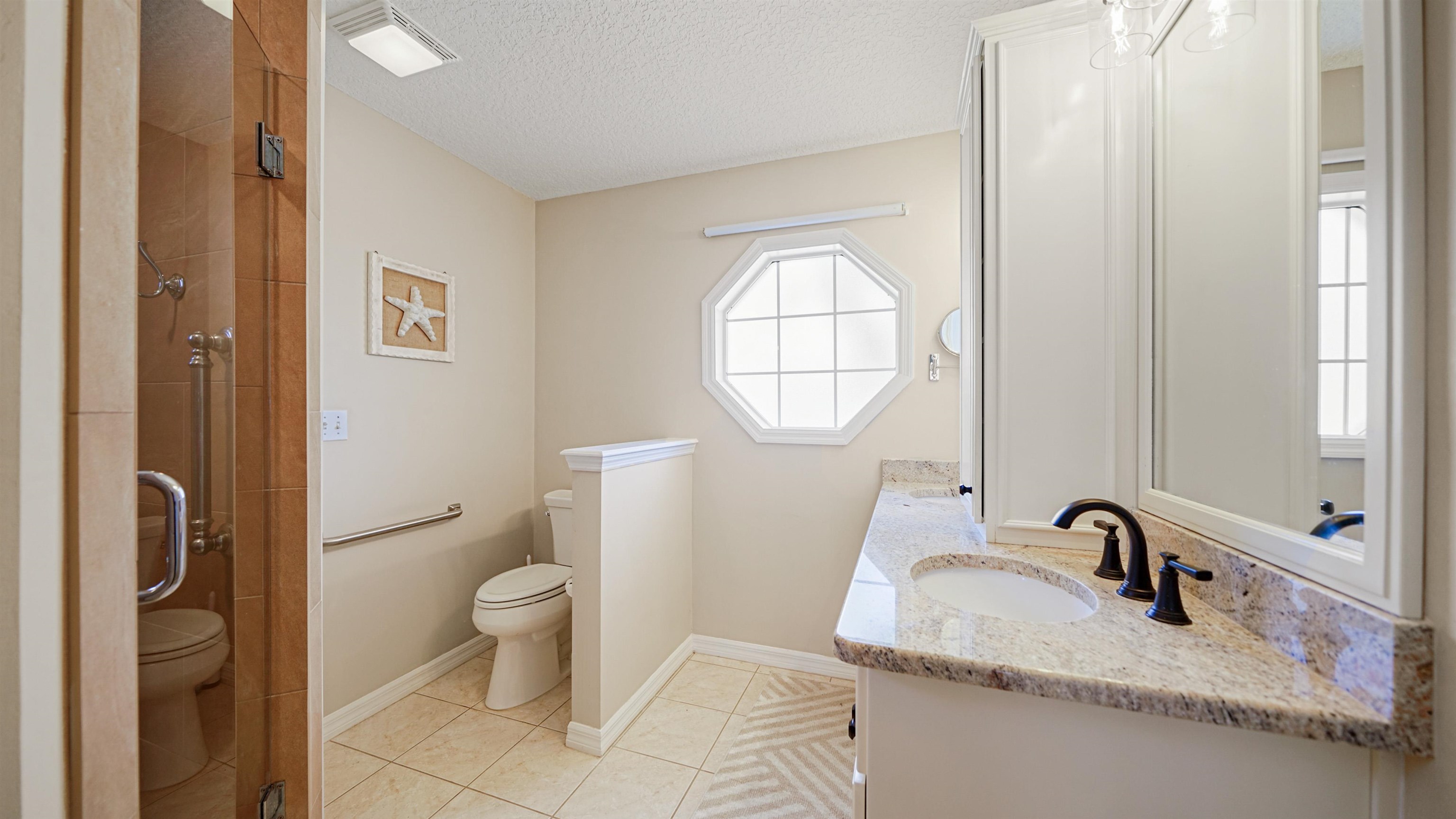 5324 5th Street St. Augustine, FL 32080 - Photo 22 of 49 a bathroom with a granite countertop sink a toilet and a mirror
