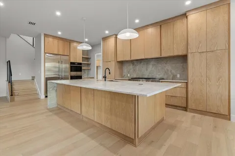a kitchen that has a lot of cabinets and wooden floor