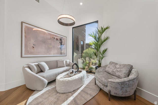 2867 East Granite Way St. George, UT 84790 - Photo 54 of 69 Bright interior space featuring a floor-to-ceiling window, wood-finish flooring, and a contemporary circular pendant light fixture