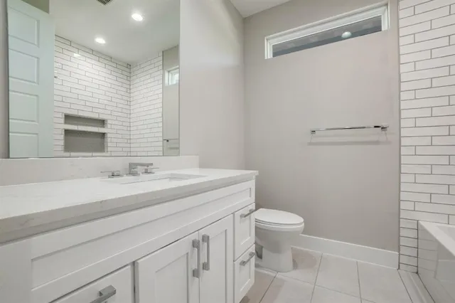 a bathroom with a sink a toilet a mirror and vanity