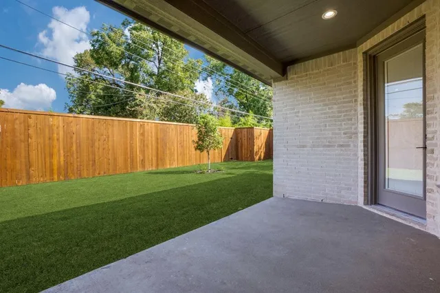 a view of backyard with plants and large tree