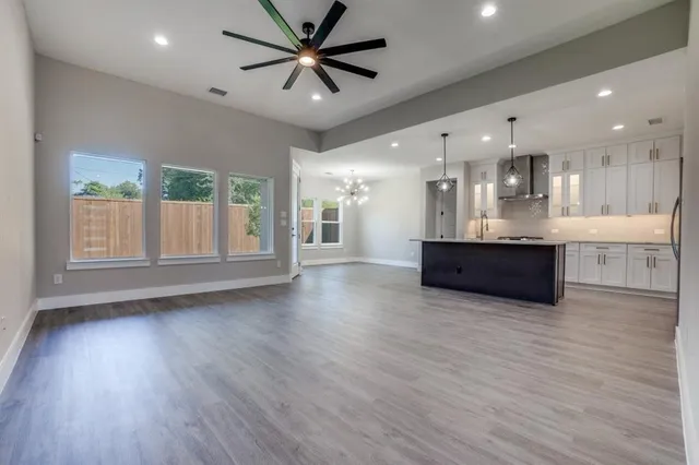 a view of a big room with wooden floor and a kitchen
