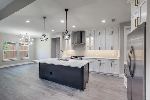 a kitchen with kitchen island a sink stainless steel appliances and cabinets